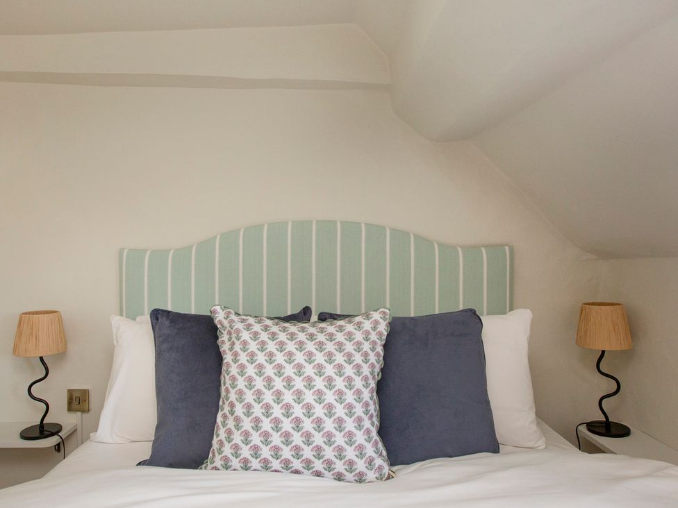 A bedroom with a bed and pillows at Apartment 2, 86 Dyer Street Cirencester