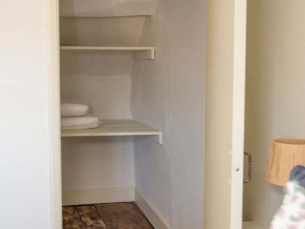 A storage room with shelves and bedding at Apartment 2, 86 Dyer Street Cirencester