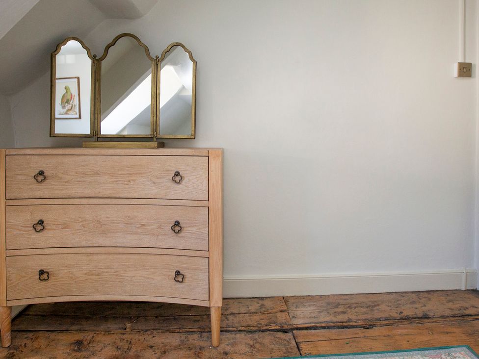 A dresser with a mirror and a picture in Apartment 2, 86 Dyer Street Cirencester