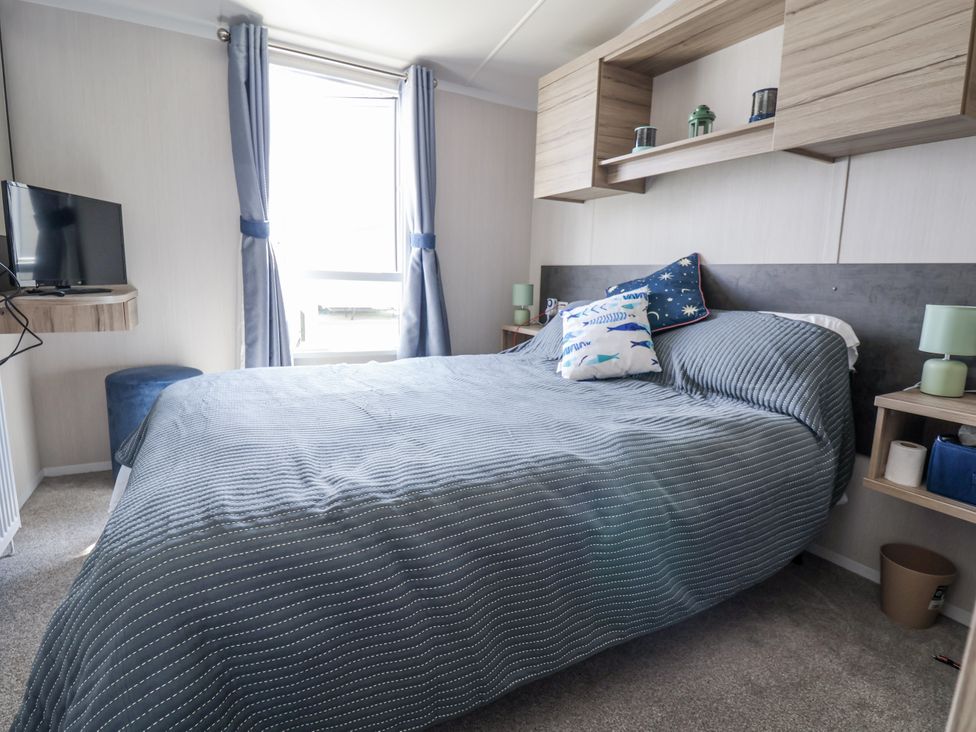 A bedroom with a bed and television at V9 Ty Mawr Holiday Park