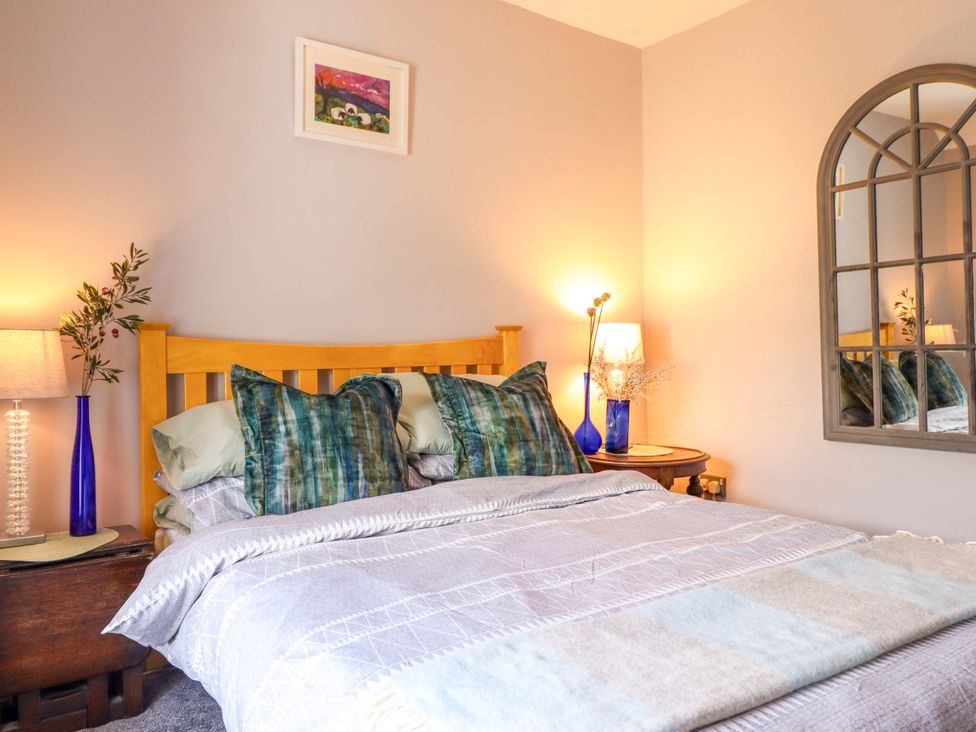 A bedroom with a bed and bedside lamps at Bwthynbach in Porthmadog