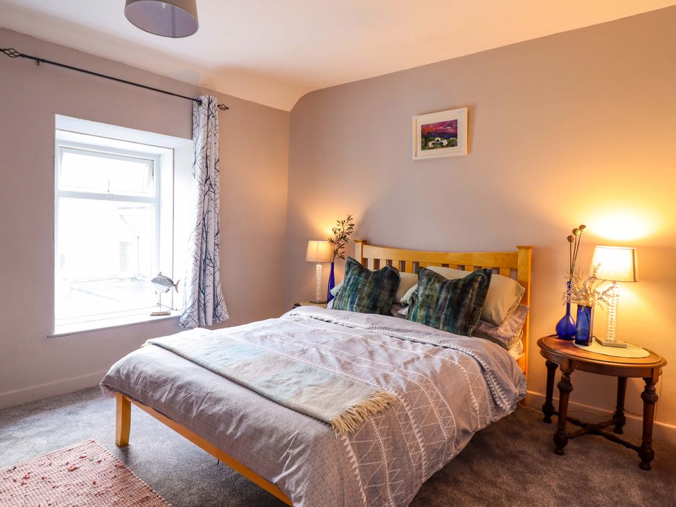 A bedroom with a bed and bedside table at Bwthynbach in Porthmadog