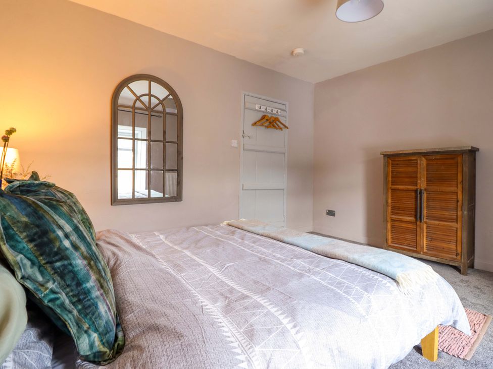 A bedroom with a bed and wardrobe at Bwthynbach in Porthmadog