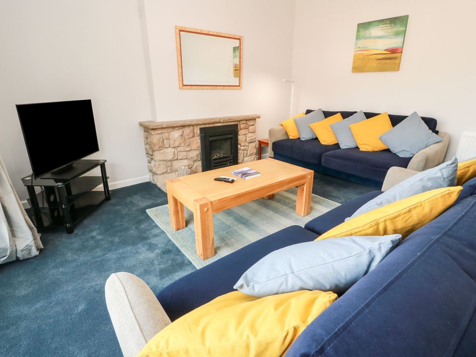 A living room with a sofa and television at Sundale in Strathaven