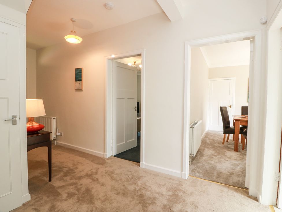 A hallway with a lamp and access to dining area at Sundale in Strathaven