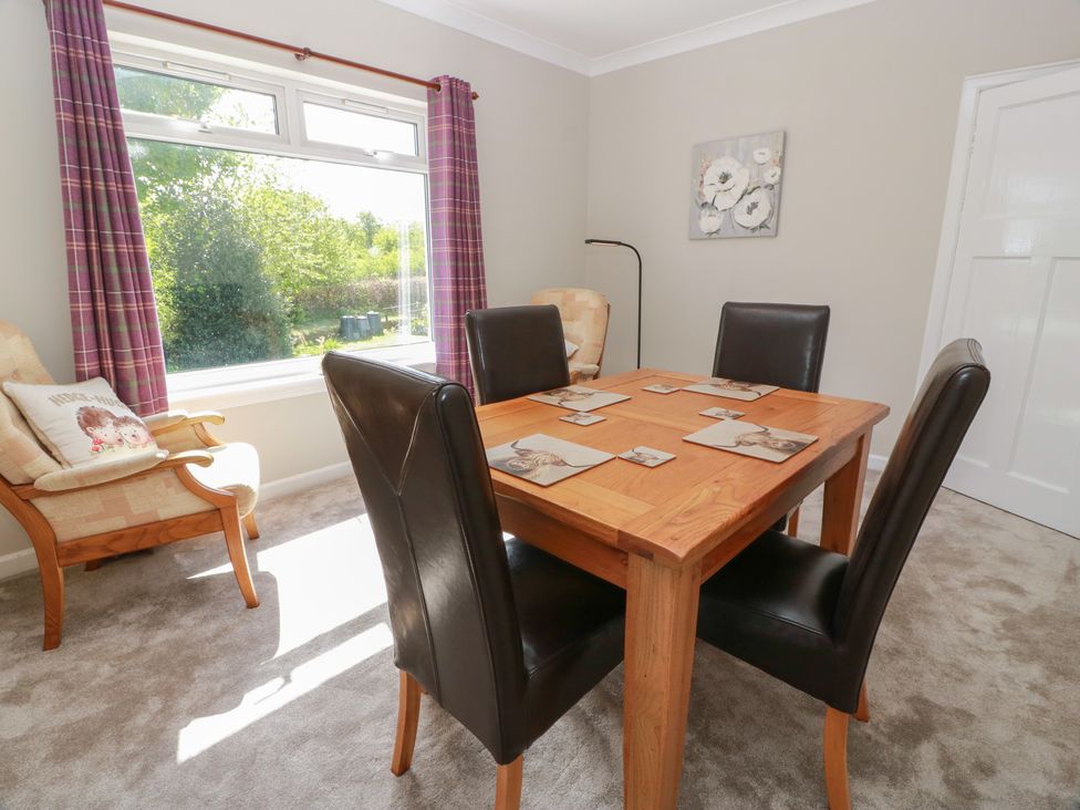 A dining room with a table and chairs at Sundale Strathaven