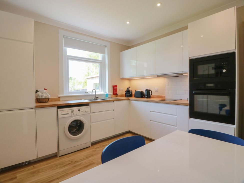 A kitchen with appliances and a dining table at Sundale in Strathaven