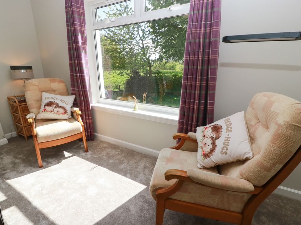 A sitting room with two armchairs and a window at Sundale in Strathaven