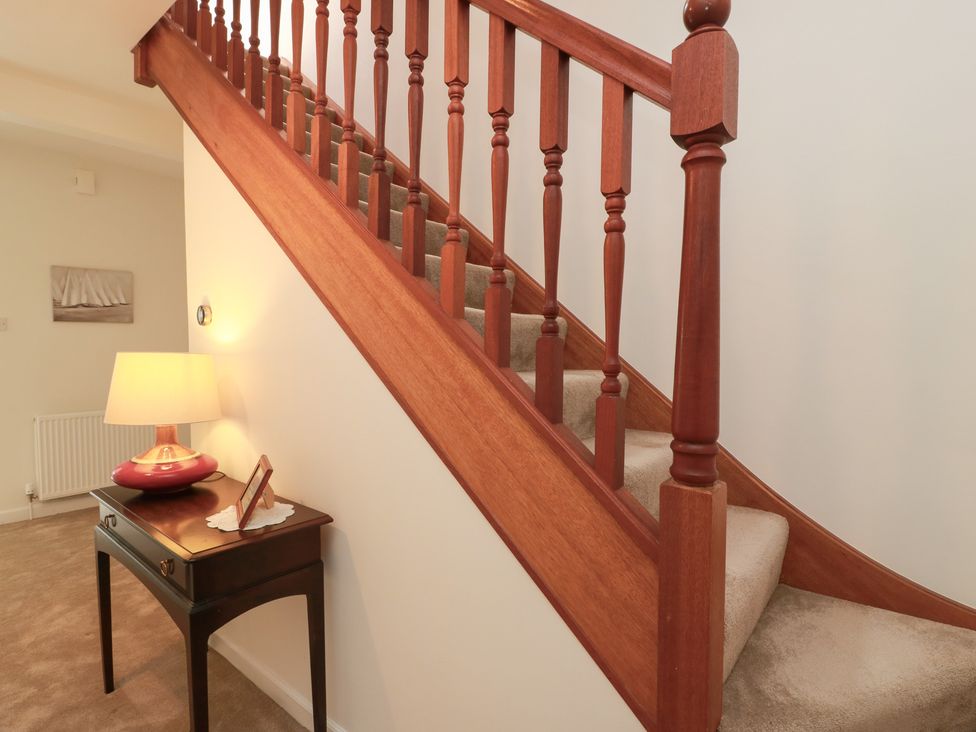 A staircase with a lamp and table in the hallway at Sundale Strathaven