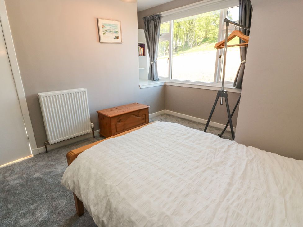 A bedroom with a bed, window, and storage chest at Sundale in Strathaven