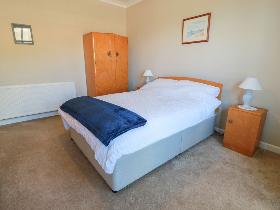 A bedroom with a bed and wardrobe at Sundale in Strathaven