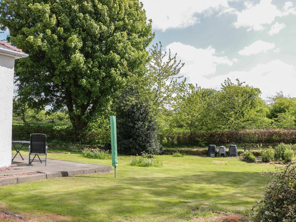 A garden with a table and chair at Sundale in Strathaven