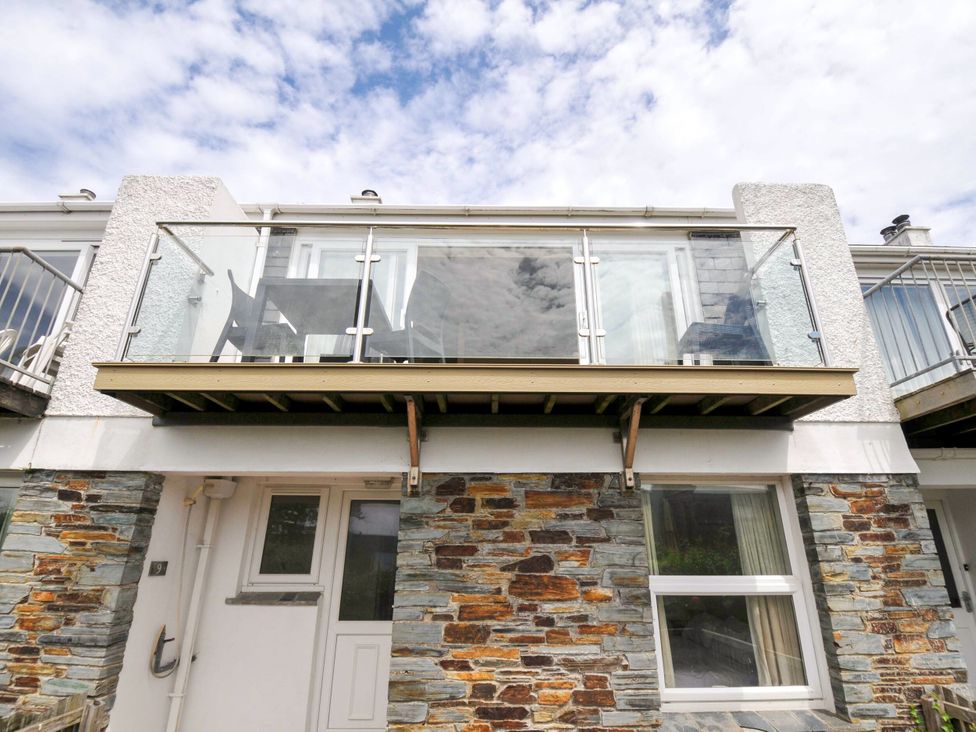 A balcony with glass railings and stone exterior at 9 Slipway Cottages Rock