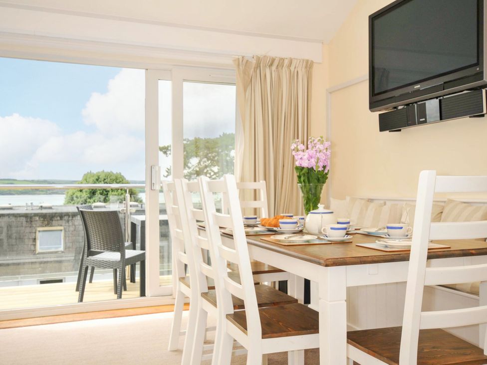 A dining room with a table and chairs at 9 Slipway Cottages in Rock