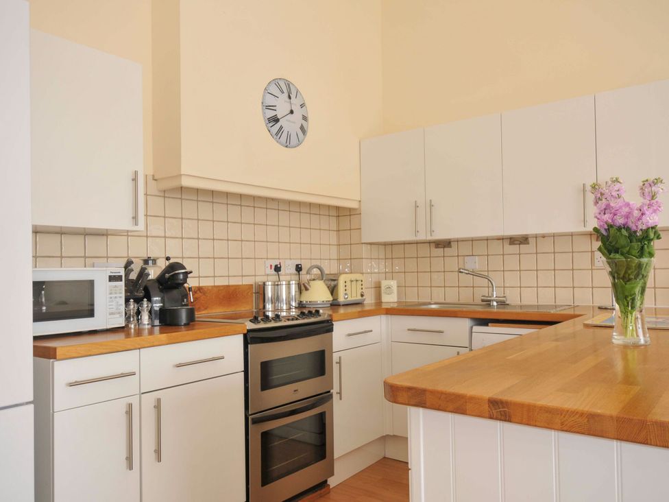 A kitchen with appliances and a vase in 9 Slipway Cottages in Rock