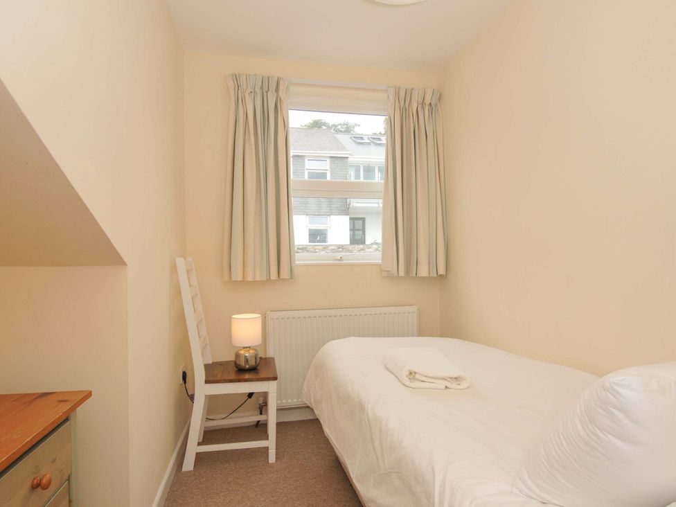 A bedroom with a bed and lamp at 9 Slipway Cottages in Rock