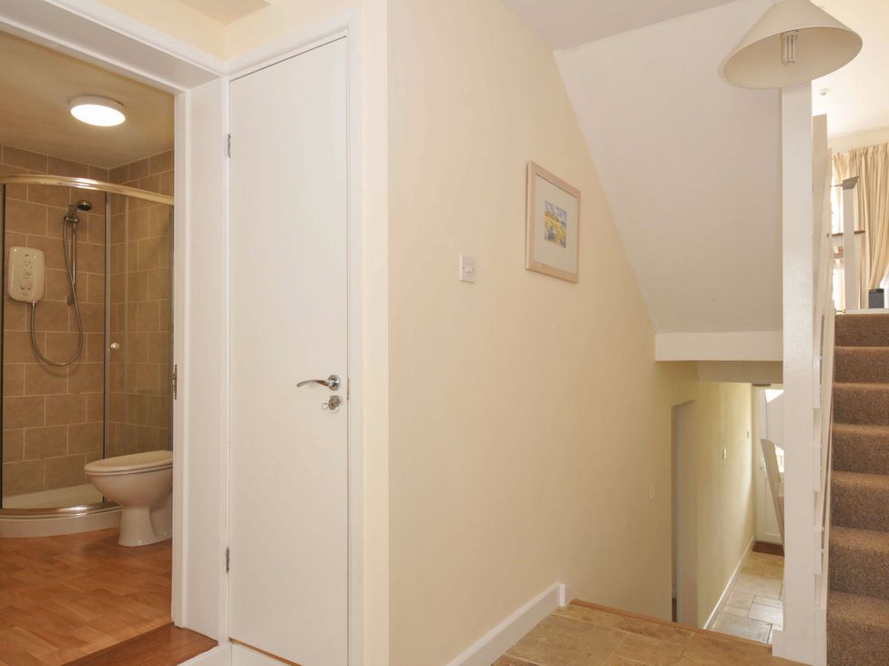 A bathroom with a shower and toilet at 9 Slipway Cottages in Rock