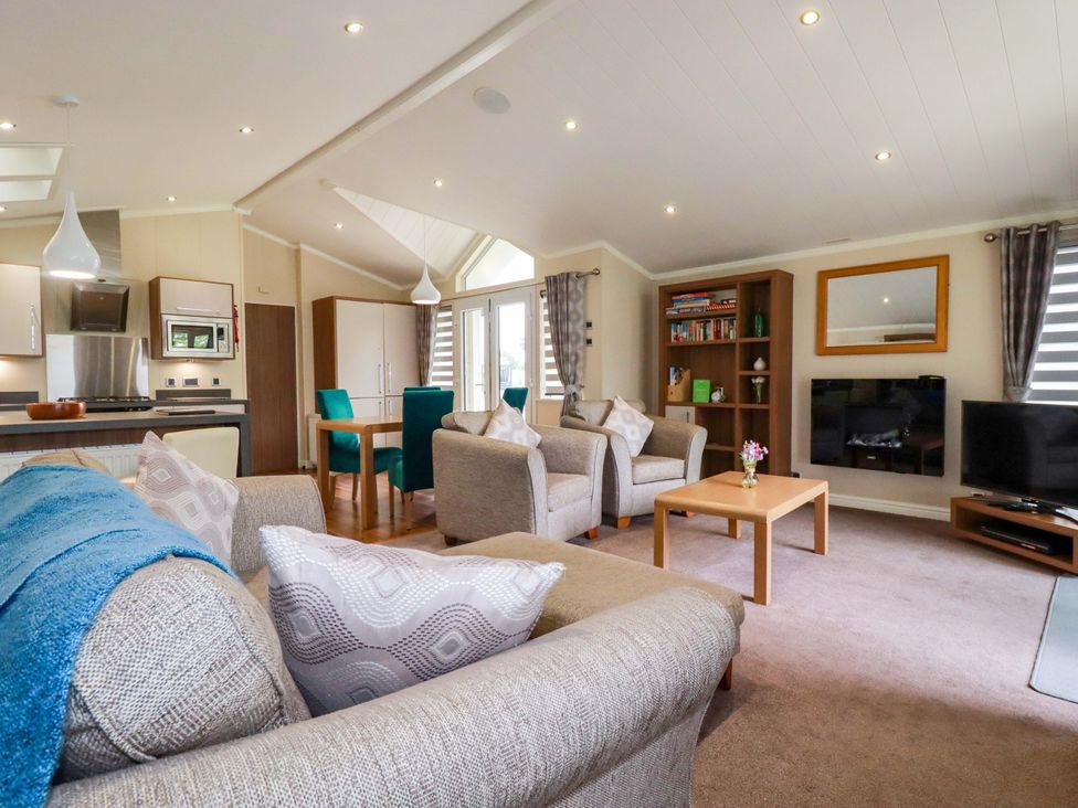A living room with a sofa, chairs, and a table at The Maples 44 St. Austell