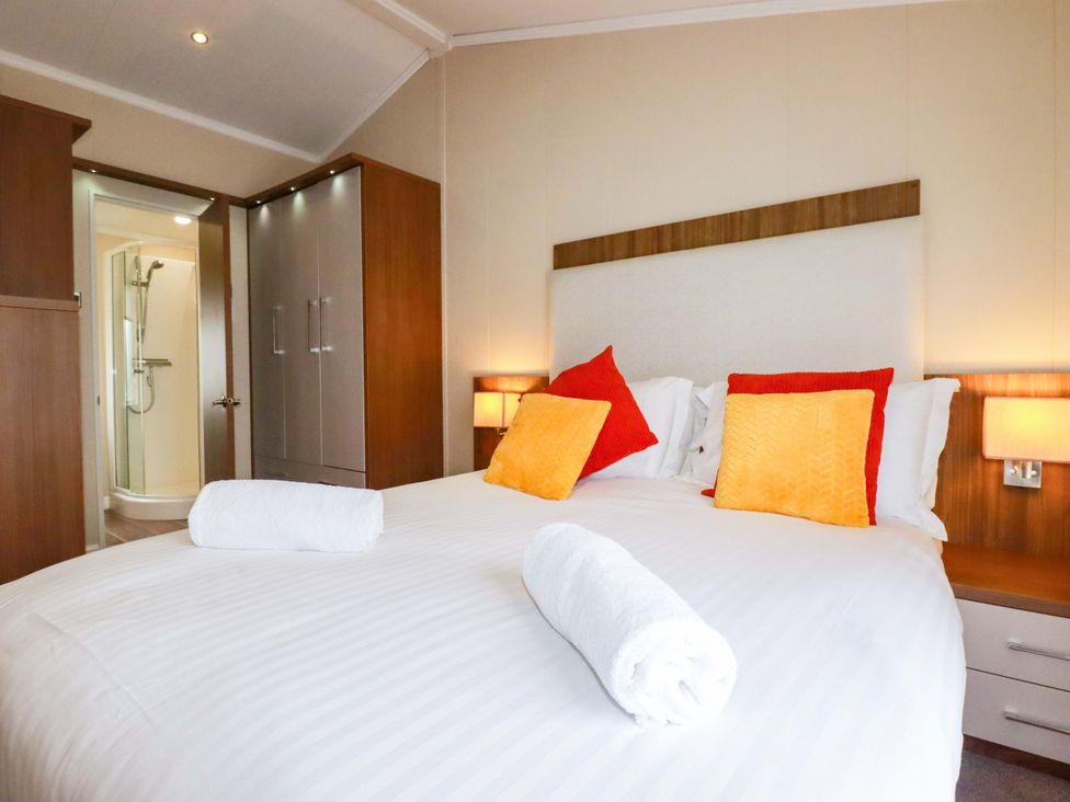 A bedroom with a bed and wardrobe at The Maples 44 St. Austell