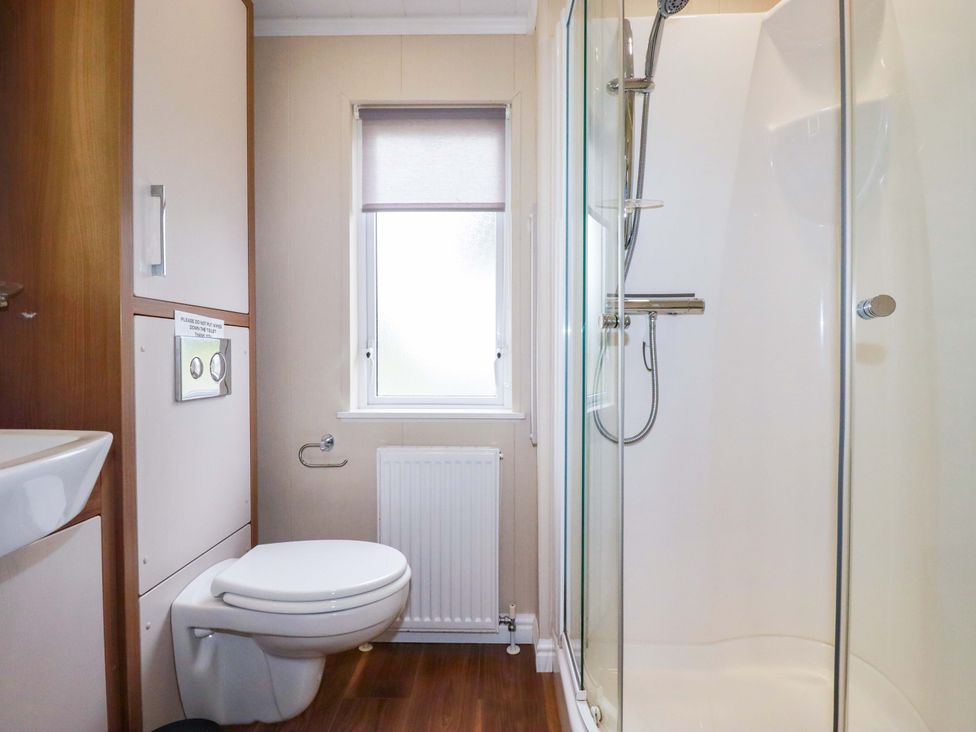 A bathroom with toilet, washbasin, shower, and window at The Maples 44 St. Austell