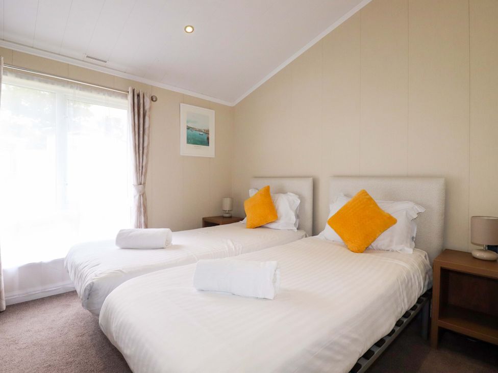 A bedroom with two beds and a nightstand at The Maples 44 St. Austell
