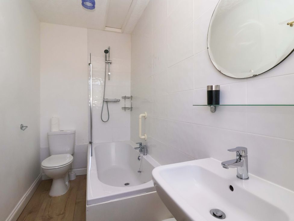 A bathroom with a bathtub, shower, toilet, and sink at Sandy Shore in Bridlington