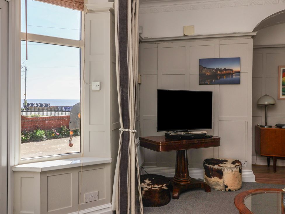 A living room with a tv and table at Sandy Shore in Bridlington