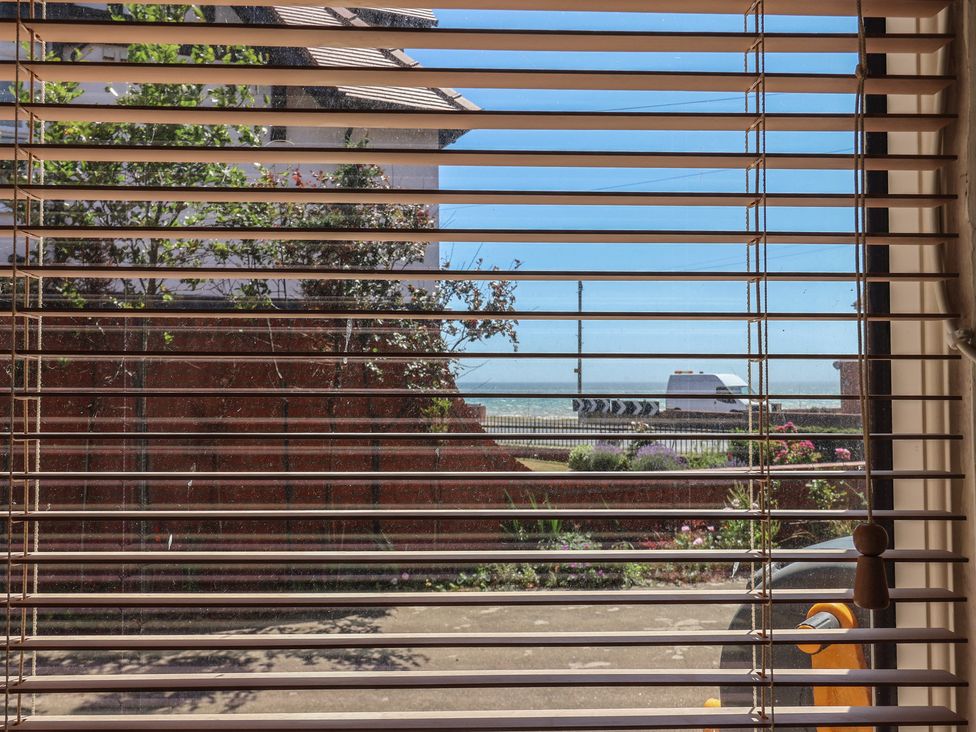 A view through blinds showing a road and ocean at Sandy Shore in Bridlington