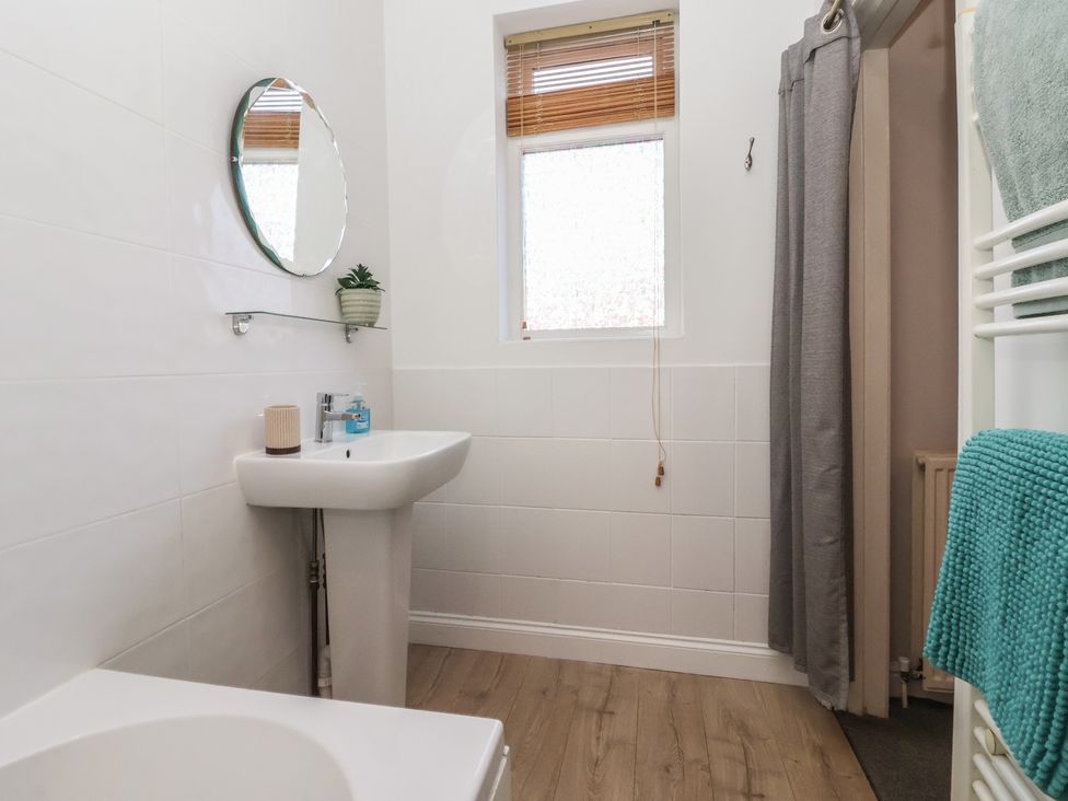 A bathroom with a sink, toilet, and mirror at Sandy Shore in Bridlington