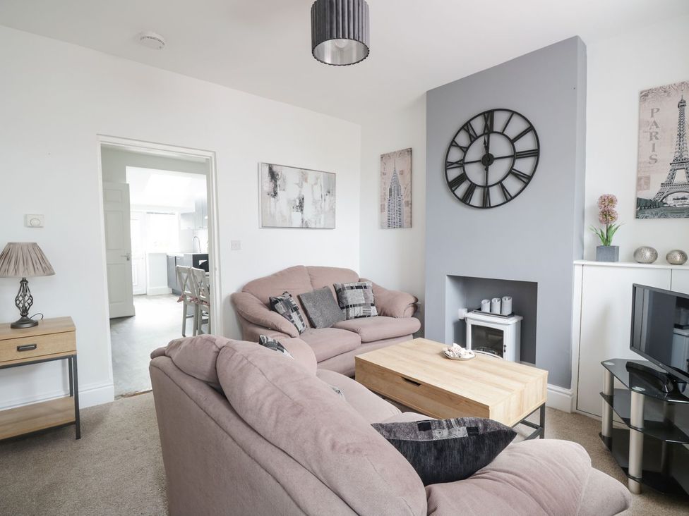 A living room with a sofa and coffee table at Billy's Cottage in Maryport
