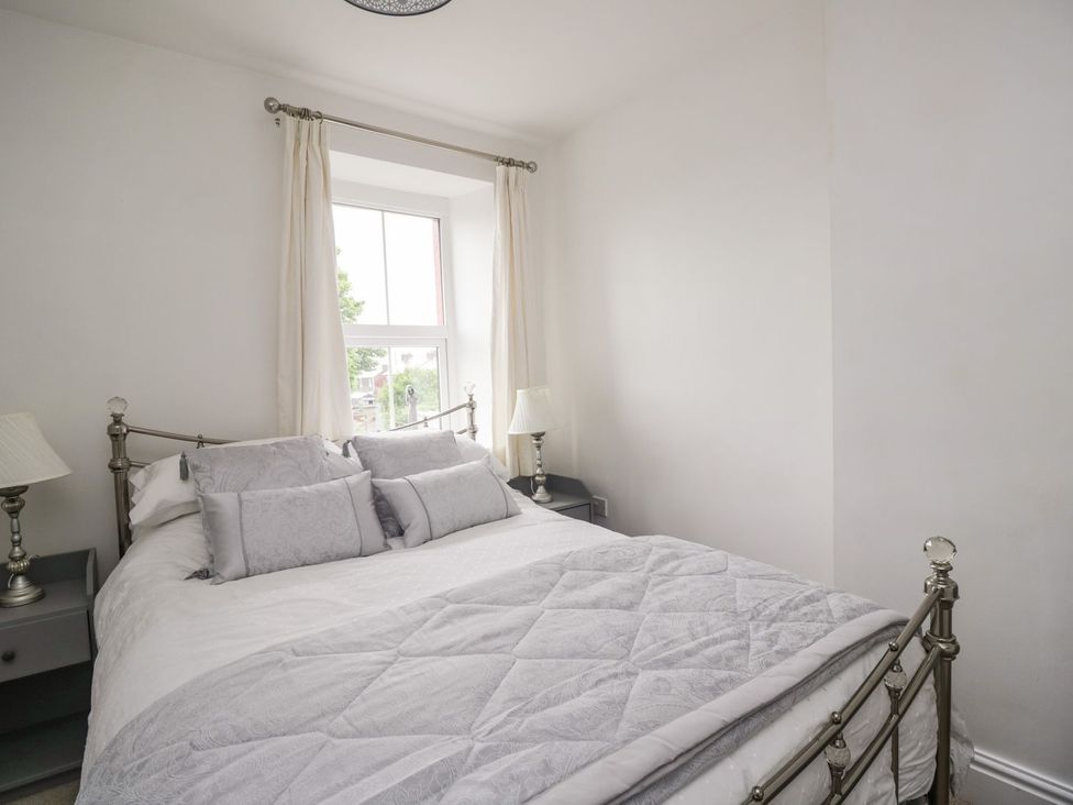 A bedroom with a bed and a window at Billy's Cottage in Maryport