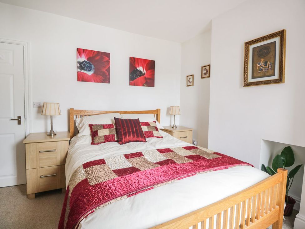 A bedroom with a bed and bedside table at Billy's Cottage in Maryport
