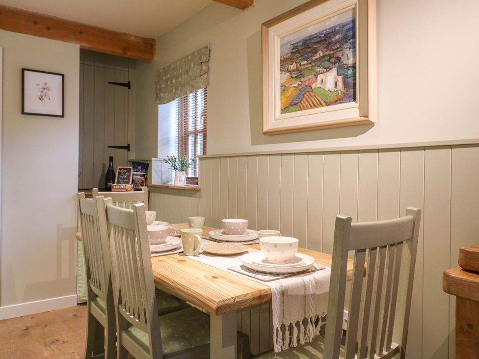 A dining room with a table set for meals at The Hayloft in Charing