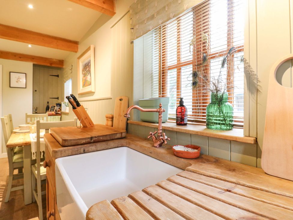 A kitchen with a sink and wooden countertops at The Hayloft in Charing