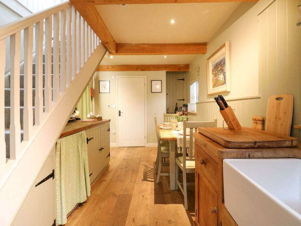 A kitchen with a dining table and chairs at The Hayloft in Charing