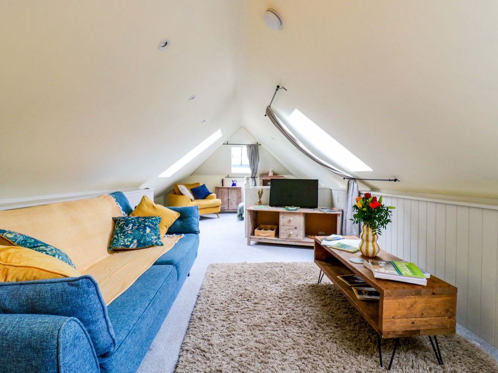 A living room with a sofa and coffee table at The Hayloft in Charing