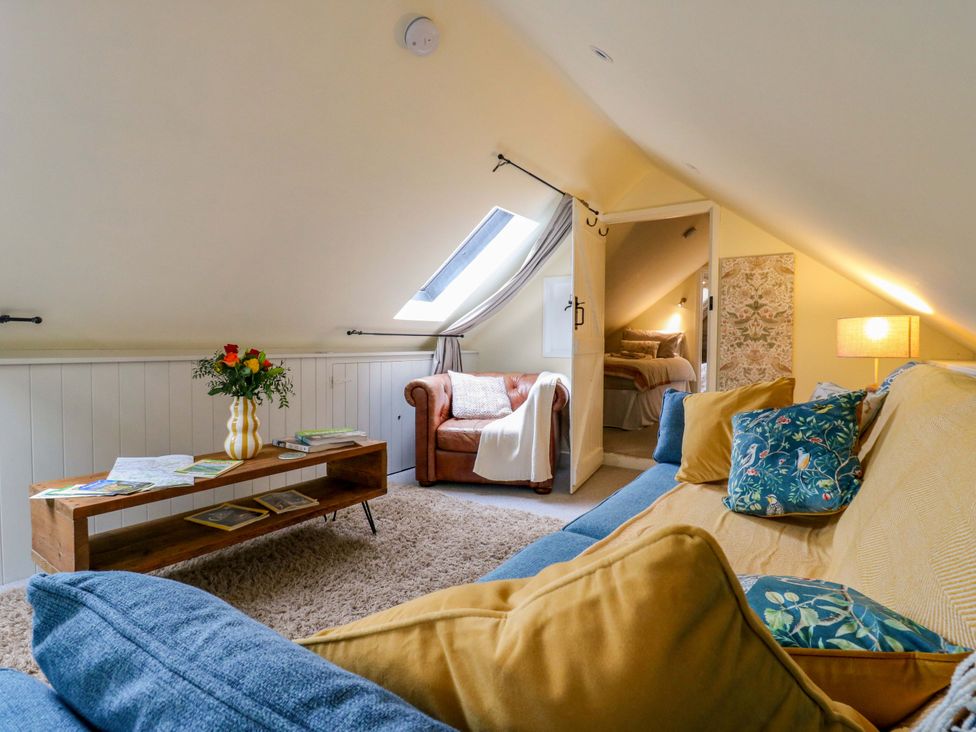 A sitting room with a sofa and coffee table at The Hayloft in Charing