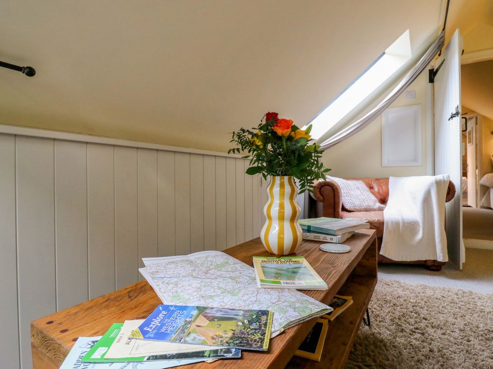 A snug with a table, map, magazines, and a sofa at The Hayloft in Charing