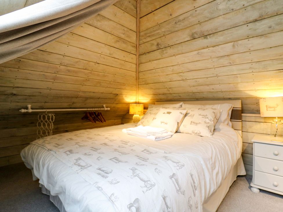 A bedroom with a bed and bedside table at The Hayloft in Charing