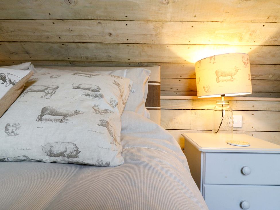 A bedroom with a bed and lamp at The Hayloft in Charing
