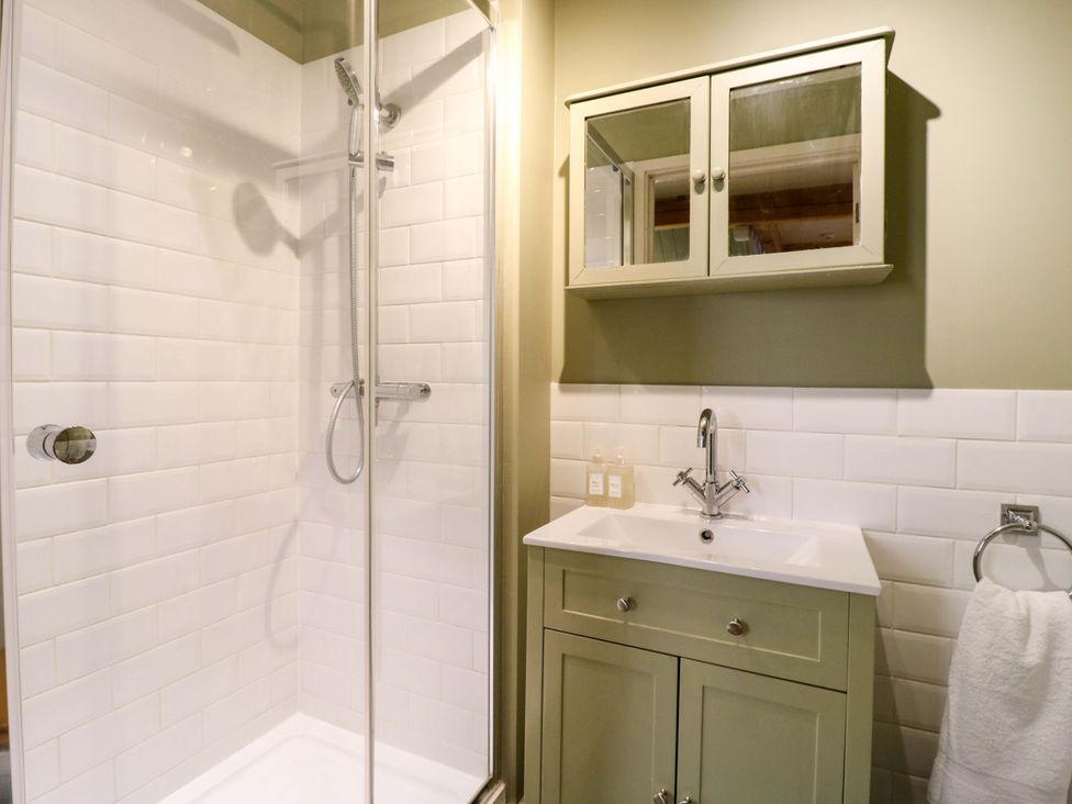 A bathroom with shower and vanity unit at The Hayloft in Charing
