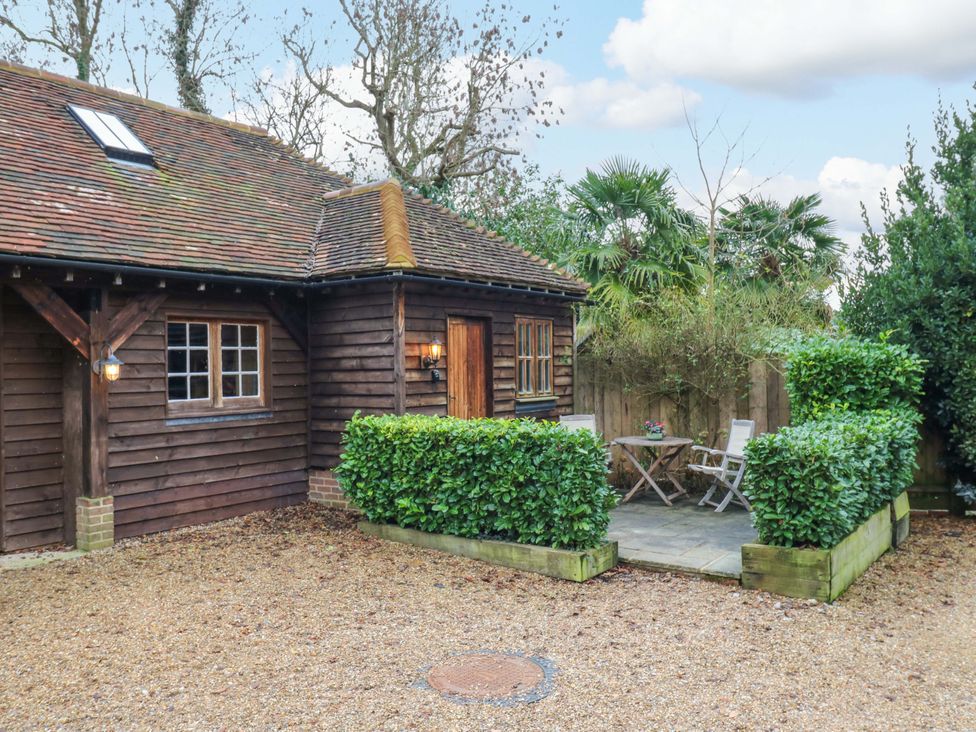 A house with a table and chairs in outdoor space at The Hayloft in Charing