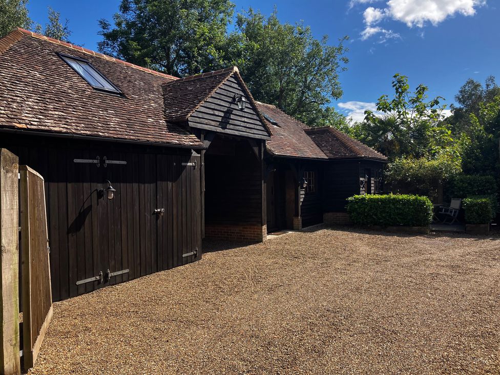 The exterior of a building with a gravel driveway at The Hayloft - Beautiful Barn Stay in Charing