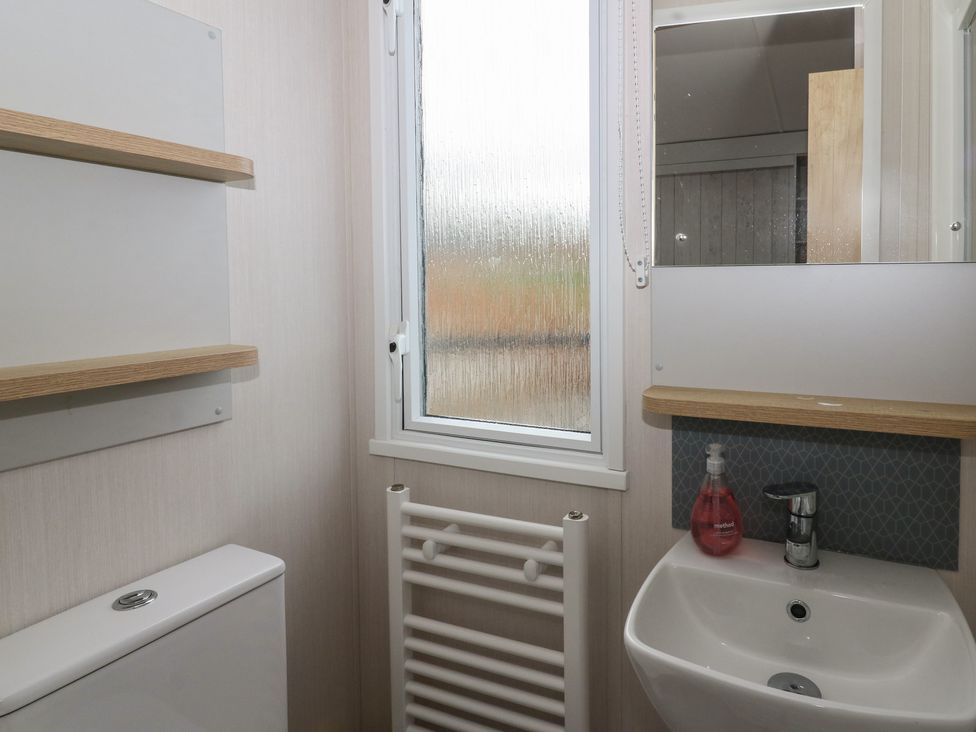 A bathroom with a toilet and sink at Hafan Y Mor in Aberporth