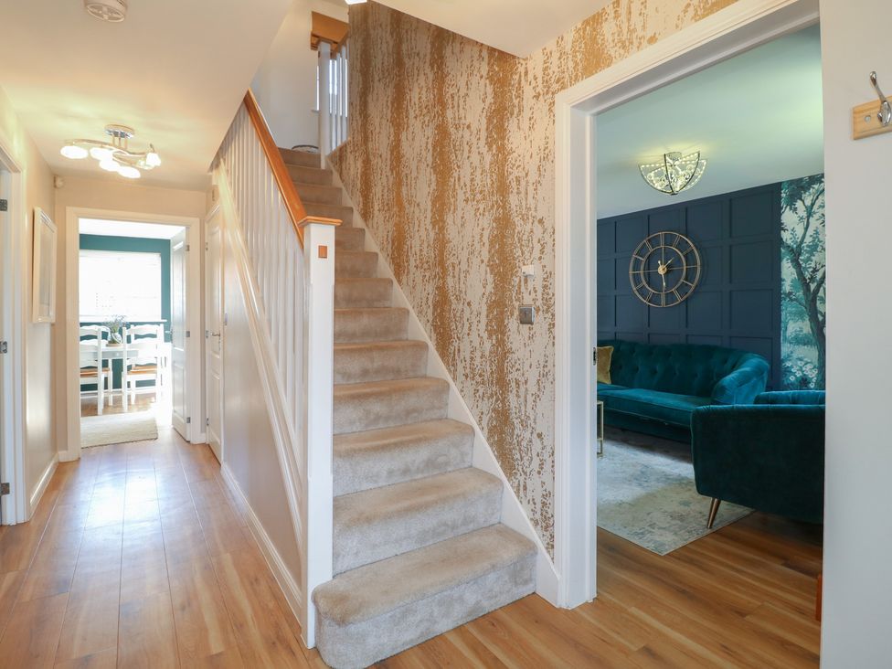 A hallway with a staircase and a sofa visible at 7 Yarnfield Parkway