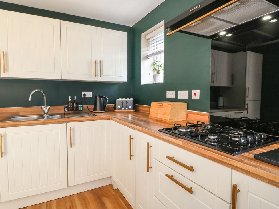 A kitchen with cabinets, sink, kettle, and stove at 7 Yarnfield Parkway