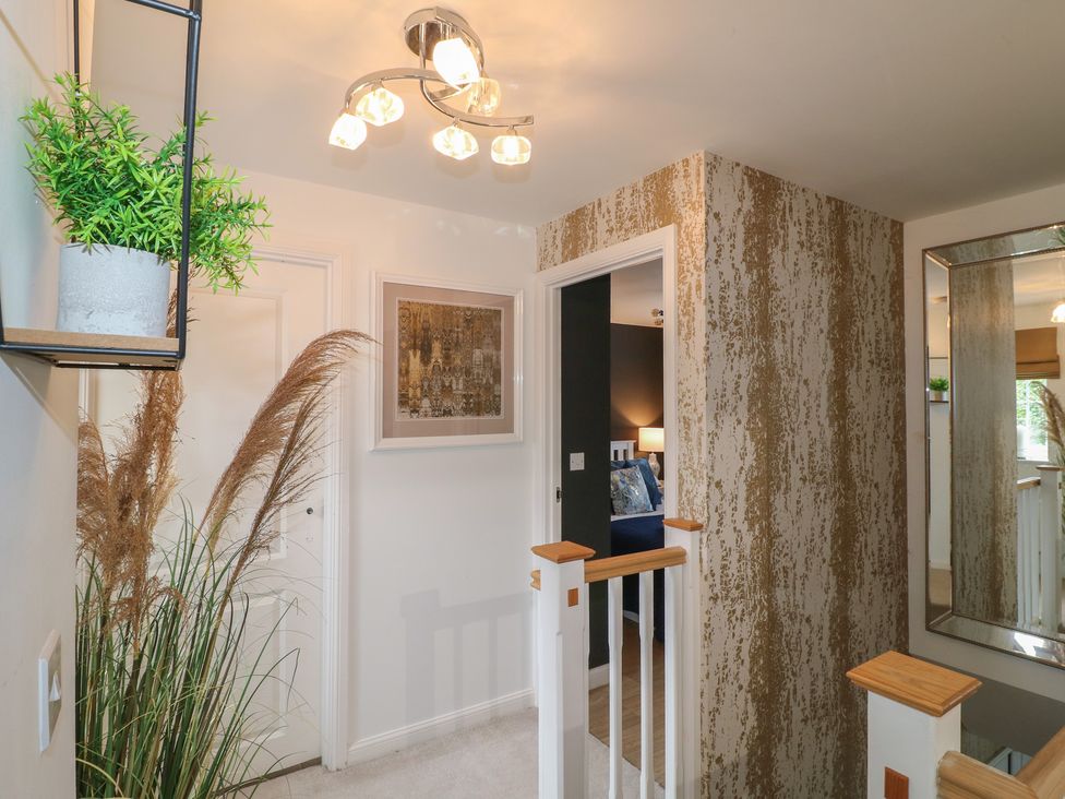 A hallway with a mirror and plant at 7 Yarnfield Parkway