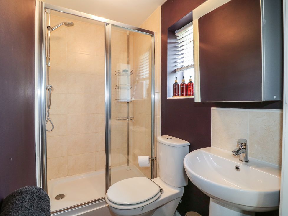 A bathroom with a shower, toilet, and sink at 7 Yarnfield Parkway