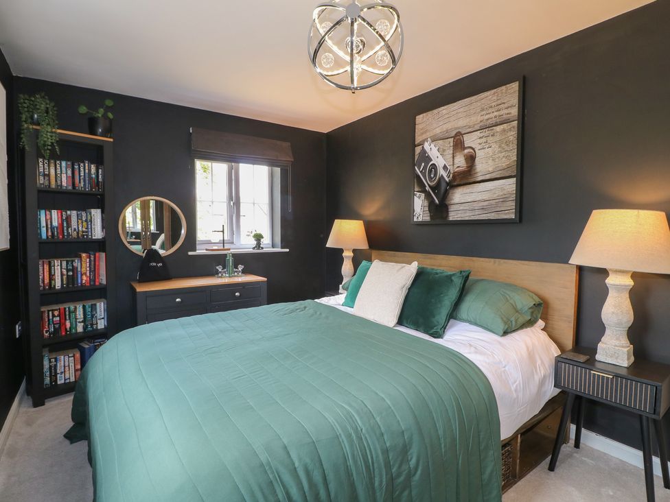 A bedroom with a bed and bookshelves at 7 Yarnfield Parkway