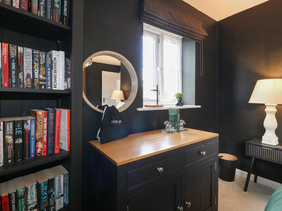 An office with a bookshelf and a desk with a lamp at 7 Yarnfield Parkway 